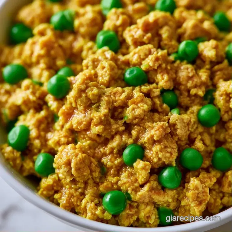 Vibrant yellow stew with tender meat and bright green peas, garnished with fresh cilantro on a dark matte plate