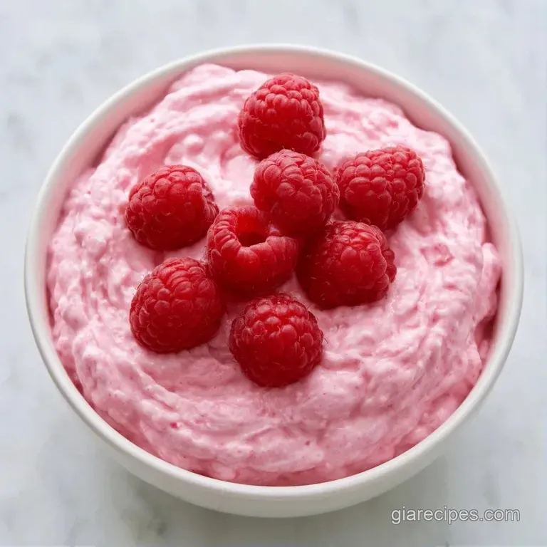 Six elegant glasses filled with light pink cream, garnished with a fresh raspberry and a small mint leaf.