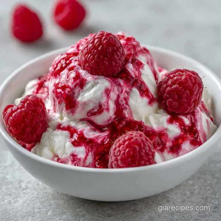 Pink marbled cream served in crystal glasses, garnished with plump fresh raspberries and tiny mint leaves.