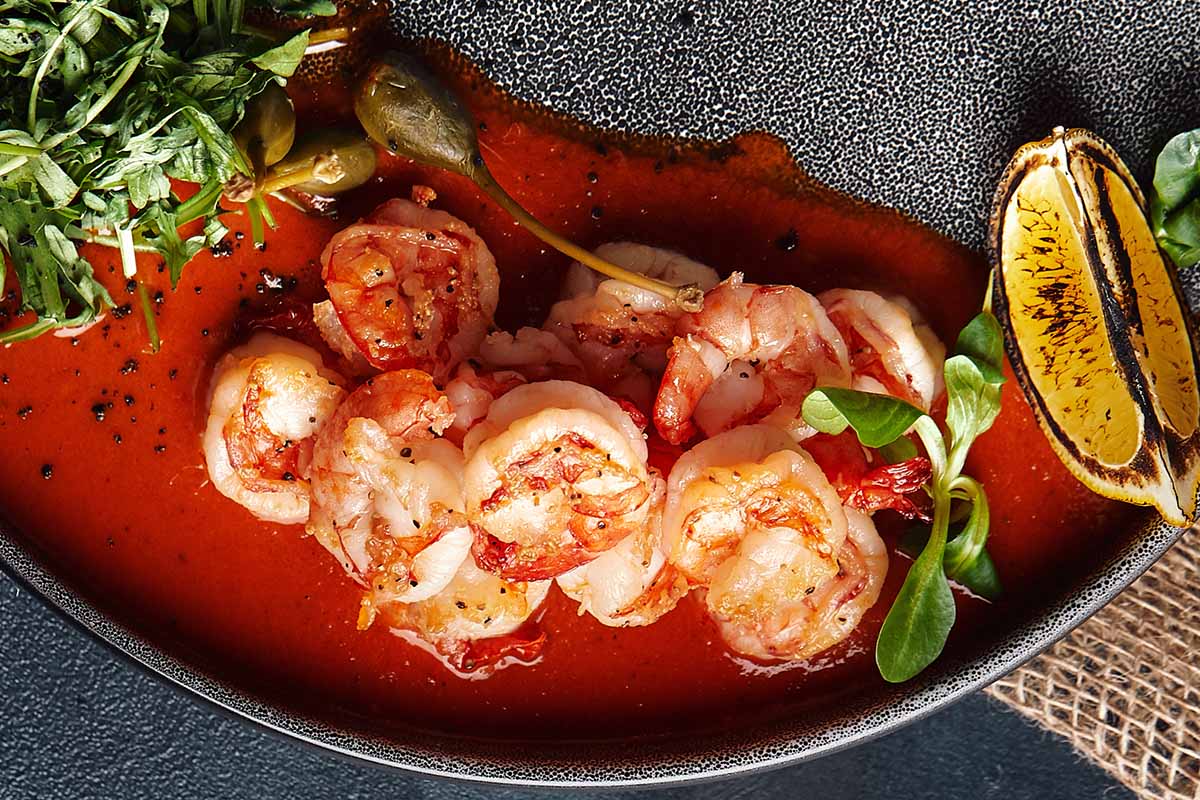 A delicious seafood boil with garlic butter sauce and Cajun spices, served in a rustic pot.