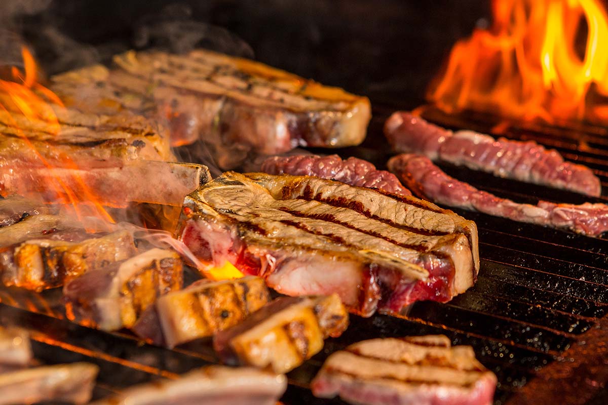 A selection of meats, seafood, and vegetables being smoked to perfection within 3 hours on a smoker.